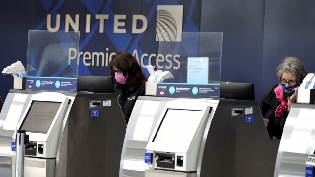 United Airlines employees work at ticket counters.