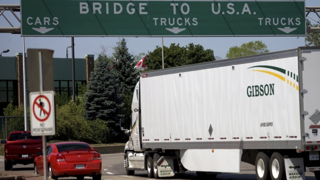 "Bridge to U.S.A." sign over highway as cars cross into the U.S. from Canada
