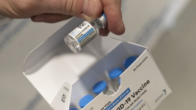 a pharmacist holds a vial of the Johnson & Johnson COVID-19 vaccine