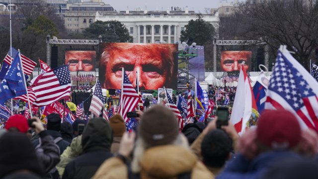 the face of President Donald Trump appears on large screens as supporters participate in a rally in Washington.