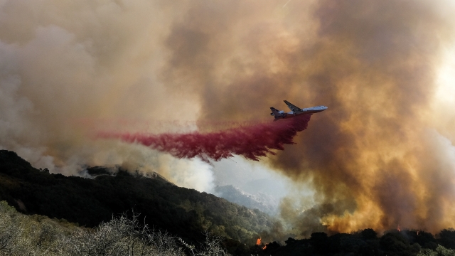 An air tanker drops retardant on a wildfire