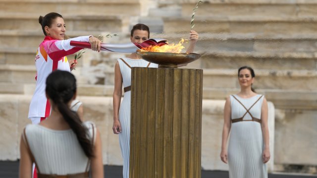 Greece's Olympic Cross Country Ski Champion lights the flame during the Olympic flame handover ceremony