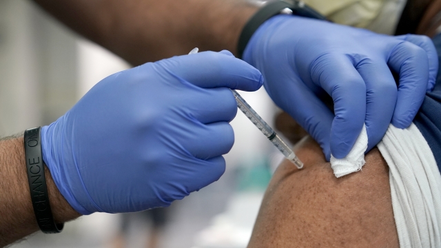 A health care worker administers a COVID-19 booster shot.