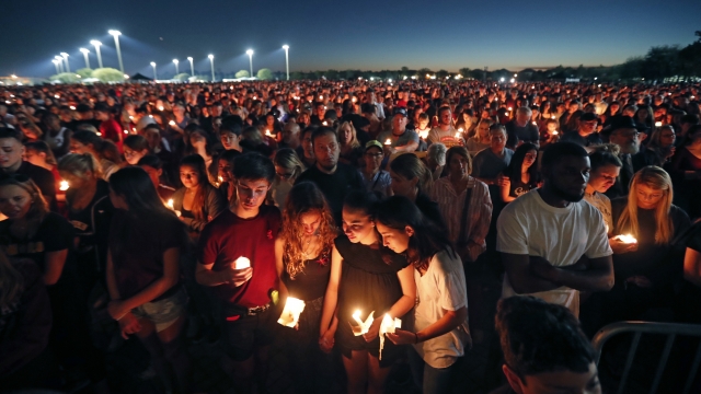 People attend a candlelight vigil for the victims of the shooting at Marjory Stoneman Douglas High School in Parkland, Fla.