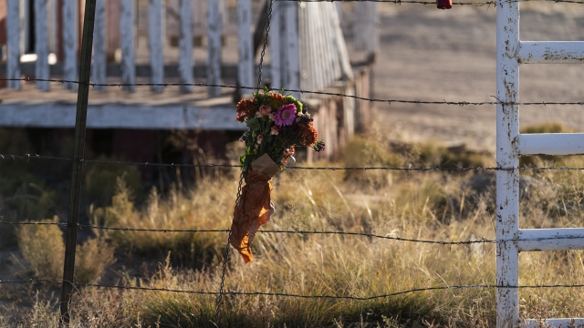 A bouquet of flowers hangs from a fence on the set of the movie "Rust"