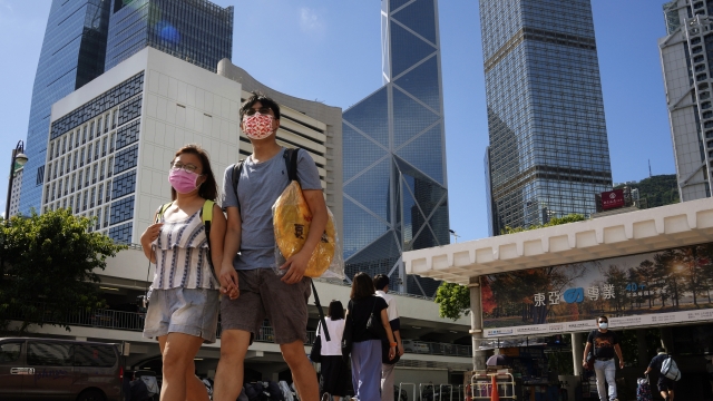 A couple walk along a street in Central business district in Hong Kong