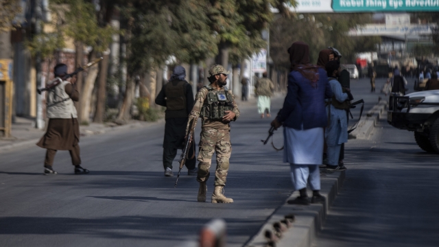 Taliban fighters block roads after an explosion.