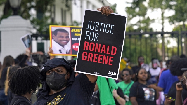 Woman holding sign that reads "Justice For Ronald Greene."