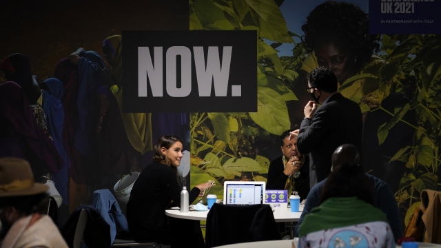 People gather gather at a table inside the venue of the COP26 U.N. Climate Summit in Glasgow, Scotland