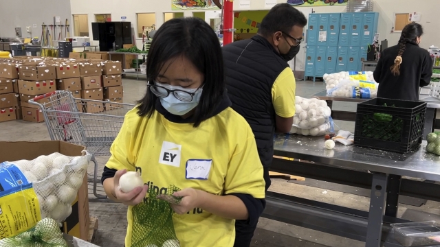A volunteer packs onions in the warehouse of a food bank.
