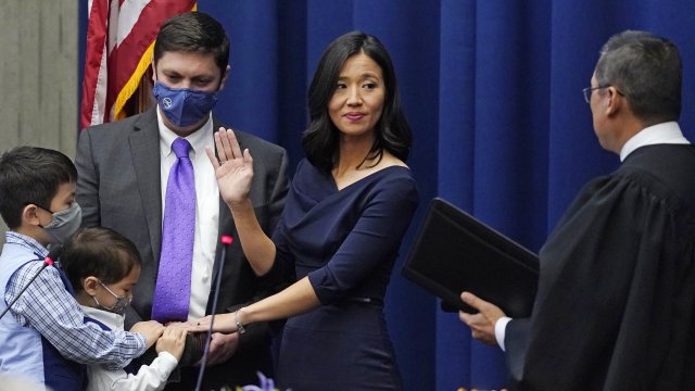 Michelle Wu raises her hand as she is sworn in as Boston mayor