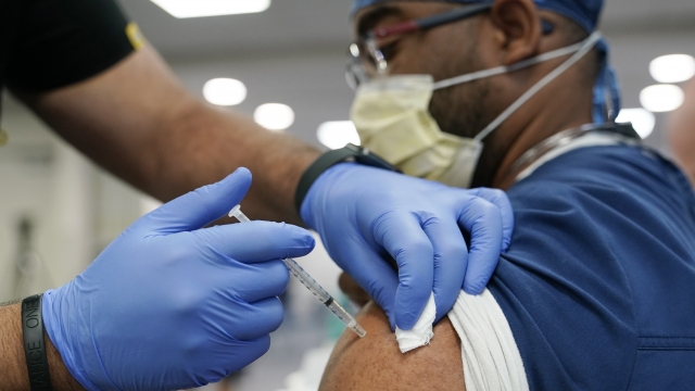 A healthcare worker receives a Pfizer COVID-19 booster shot