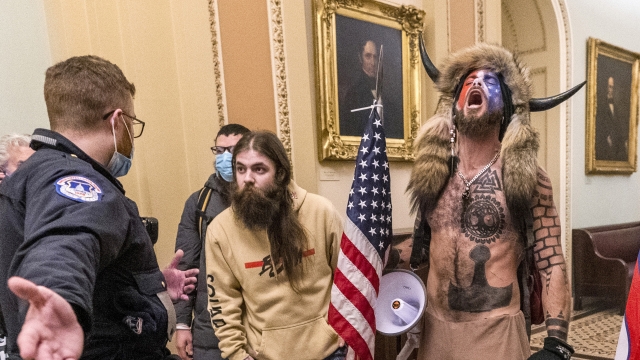 Jacob Chansley and others are confronted by U.S. Capitol Police officers outside the Senate Chamber inside the Capitol.