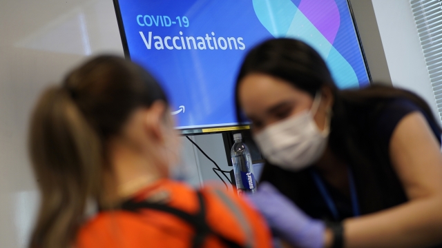A registered nurse administers a COVID-19 vaccine
