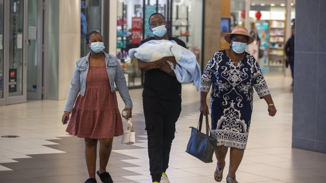People with masks walk at a shopping mall in Johannesburg, South Africa, Friday Nov. 26, 2021.