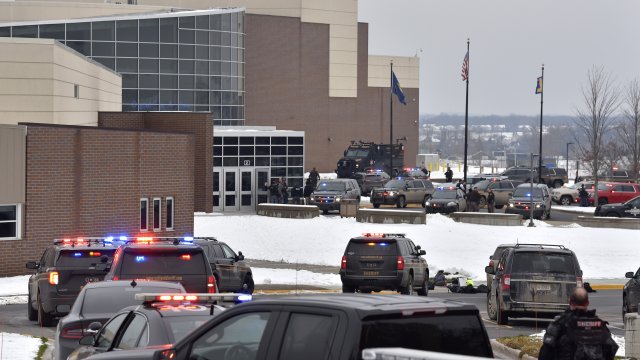 Dozens of police, fire, and EMS personnel work on the scene of a shooting at Oxford High School.