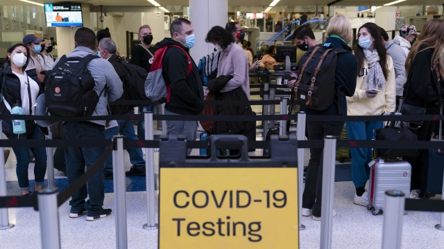 Travelers wait in line at a COVID-19 testing site at Los Angeles International Airport