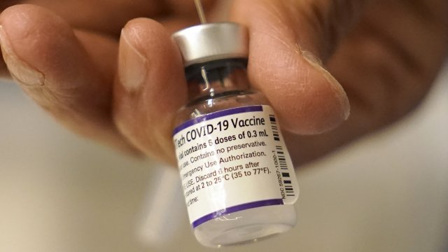 A doctor draws a dose of COVID vaccine