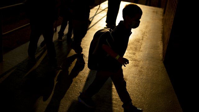 A student arrives as the sun rises during the first day of school.