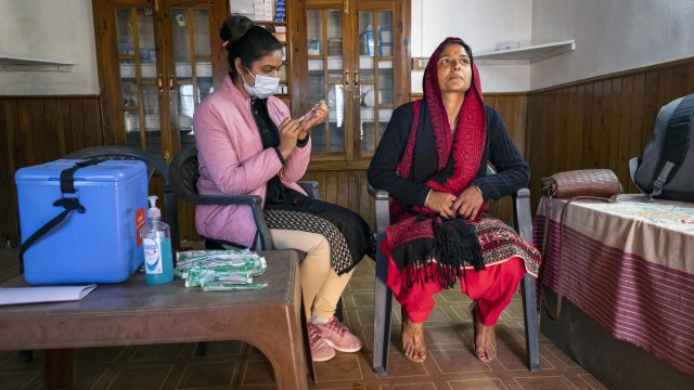A woman waits to get a Covishield vaccine for COVID-19 at a Primary Health Centre in Dharmsala, India.