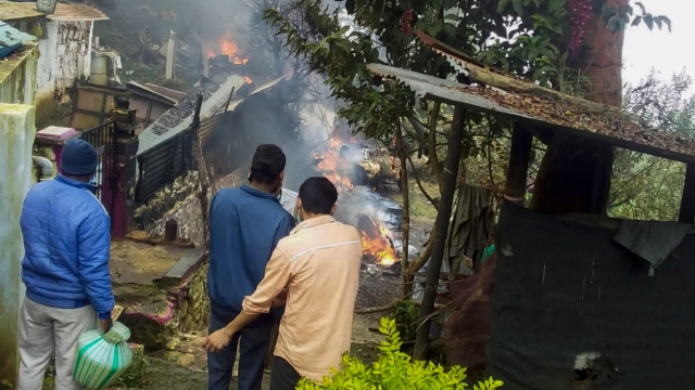 People look at a fire that erupted when after an army helicopter crashed.