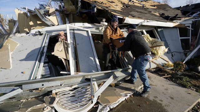People sort through tornado debris on Saturday, Dec. 11, 2021.