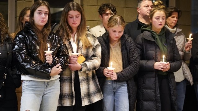 Students holding candles attend a vigil