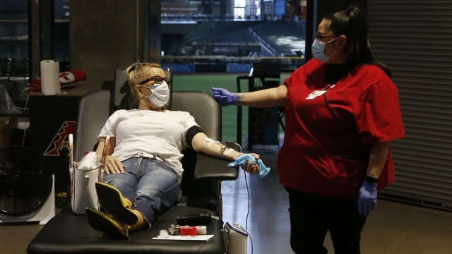 A person donates blood as they talk with an American Red Cross staffer during at Chase Field Tuesday, April 28, 2020.