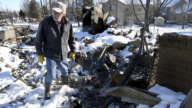 Rex Hickman sifts through the rubble of his burned home in Louisville, Colorado