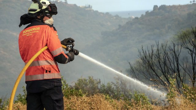 A firefighter works to tame a flame.