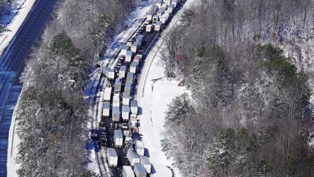 Drivers wait for traffic to be cleared as cars and trucks are stranded on sections of Interstate 95
