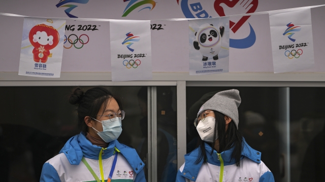 Volunteers wearing face masks at an information booth for the Beijing Winter Olympics Games
