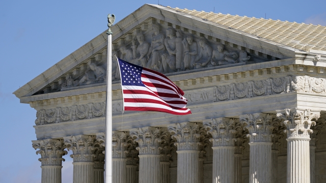 An American flag waves in front of the Supreme Court building on Capitol Hill