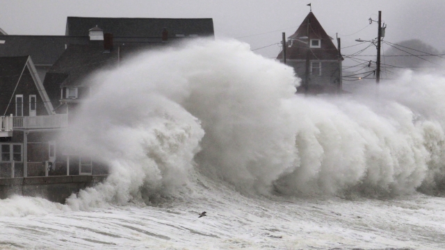 Waves crash into a seawall and buildings