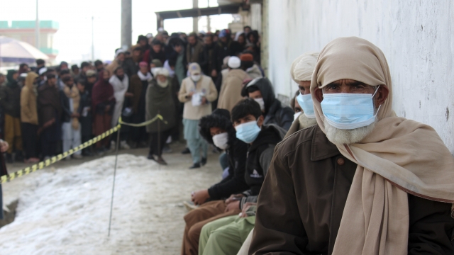 Afghans wait in line for food rations