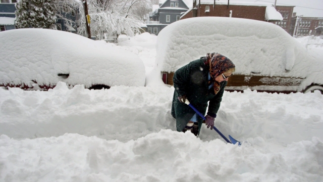 A woman shovels snow.