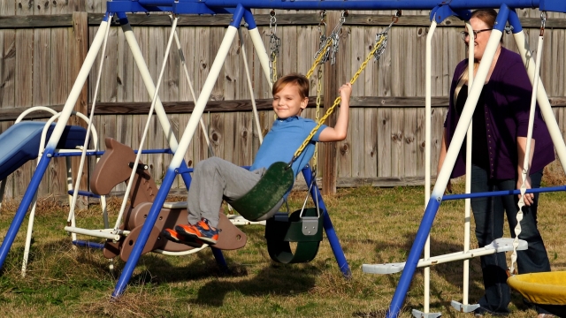 A boy swings on a swing set.