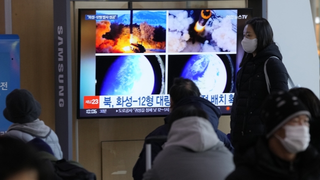 People watch a TV showing North Korea's missile launch.