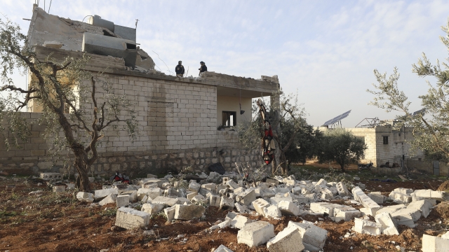 People check at a destroyed house after an operation by the U.S. military in the Syrian village of Atmeh