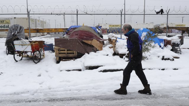 A man walks by tents.