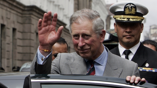Britain's Prince Charles waves after a welcoming ceremony at the presidential palace in Quito