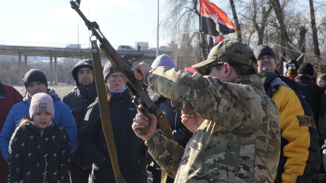 An instructor shows a Kalashnikov assault rifle as members of a Ukrainian far-right group train