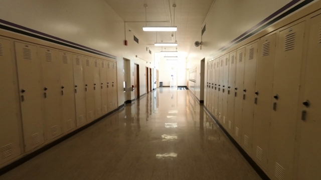 Empty school hallway lined with student lockers