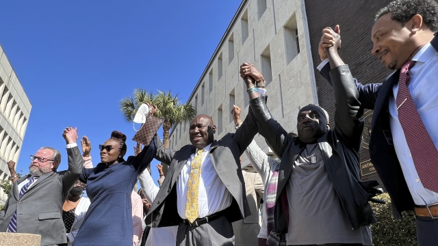 The family and attorneys of the Ahmaud Aubery raise their arms in victory after all three men were found guilty