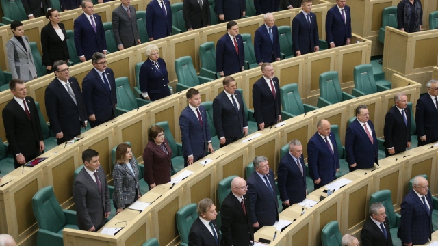 Lawmakers of the Federation Council of the Federal Assembly of the Russian Federation listen to the national anthem