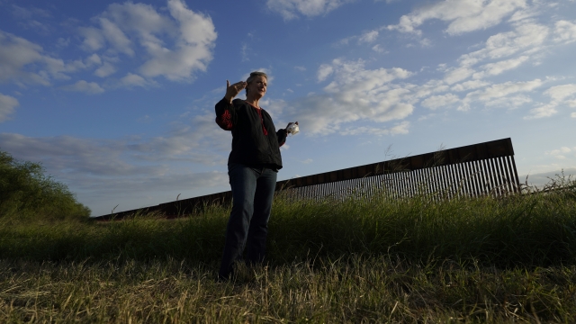 Marianna Treviño Wright stands near border wall.