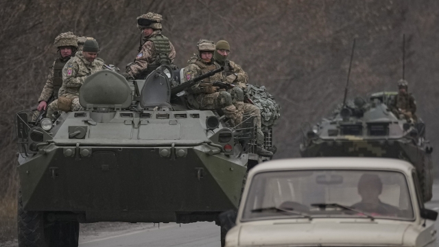 Ukrainian servicemen sit atop armored personnel carriers