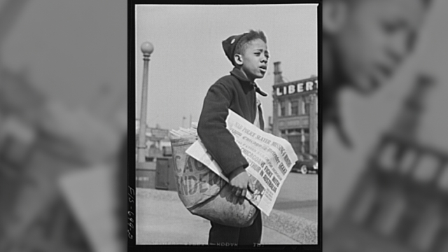 A newsboy selling the Chicago Defender
