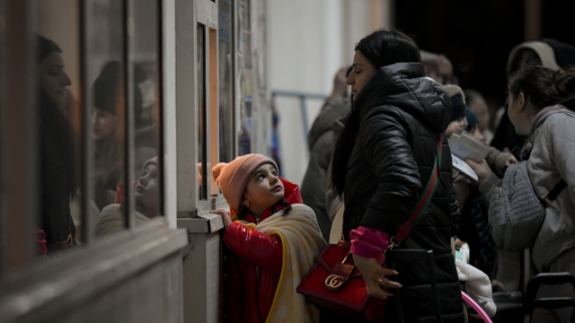 A girl from Ukraine looks up at her mother as they wait to gain entry into Romania