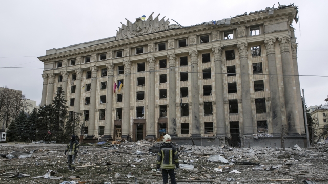 A member of the Ukrainian Emergency Service looks at the City Hall building following shelling in Kharkiv, Ukraine